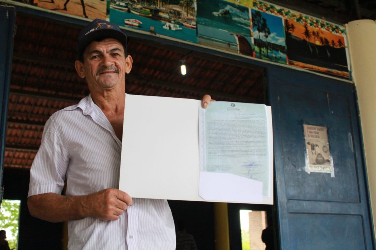 Agricultor com títulos de propriedade em mãos